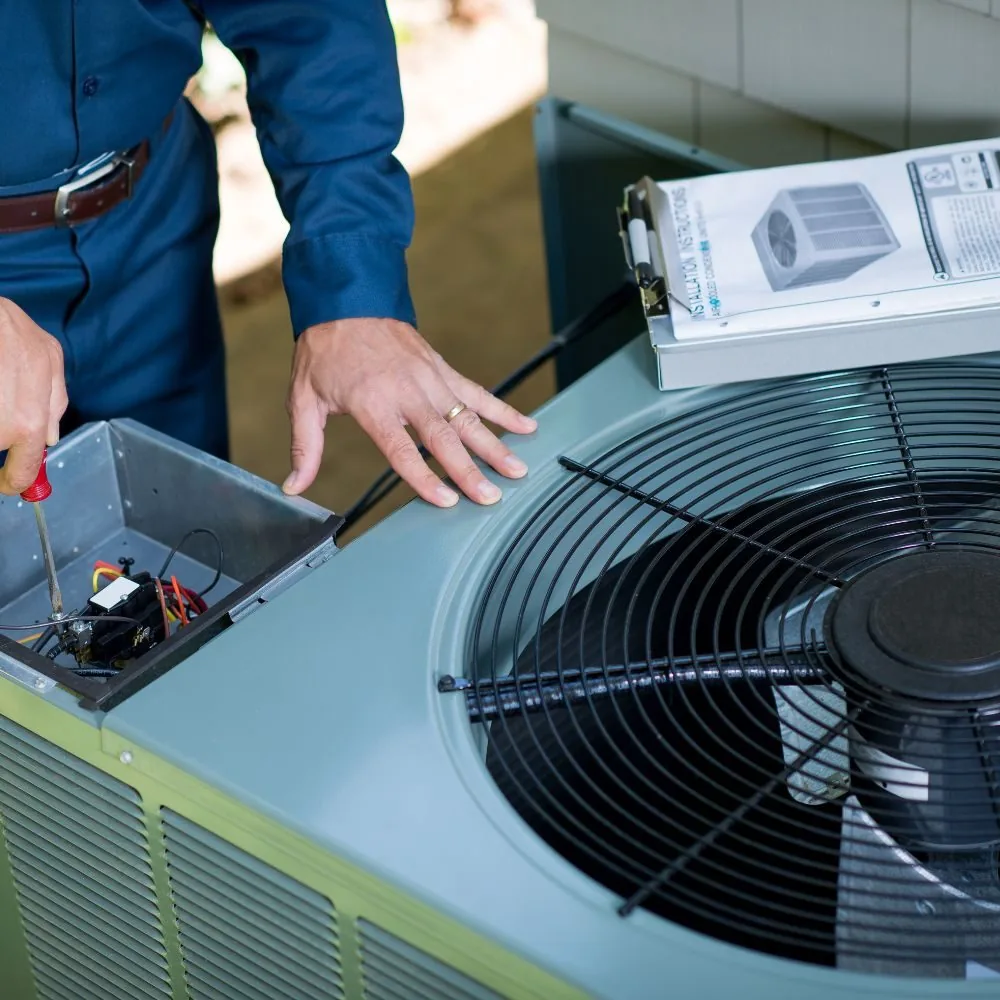 Technicien frigoriste AC Solutions intervenant sur un groupe extérieur de climatisation en Wallonie